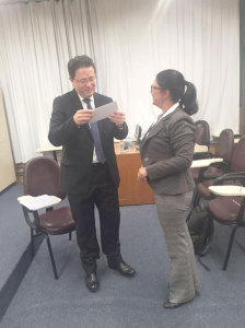 Raul Anselmi Junior recebe o certificado de aprovação das mãos da Professora Lúcia Noronha